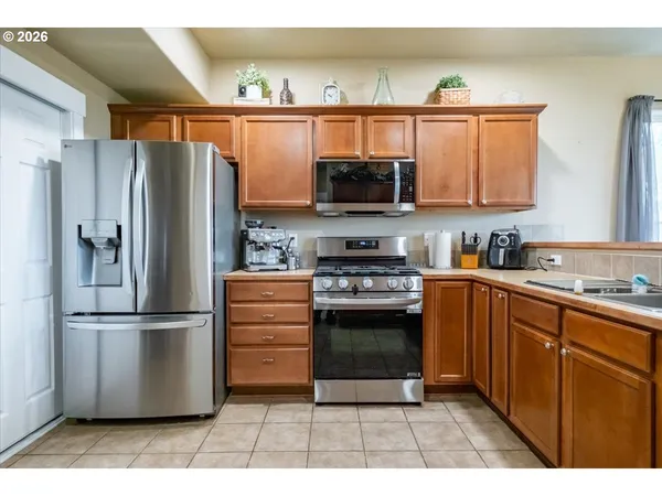 a kitchen with stainless steel appliances kitchen island granite countertop a refrigerator stove and microwave