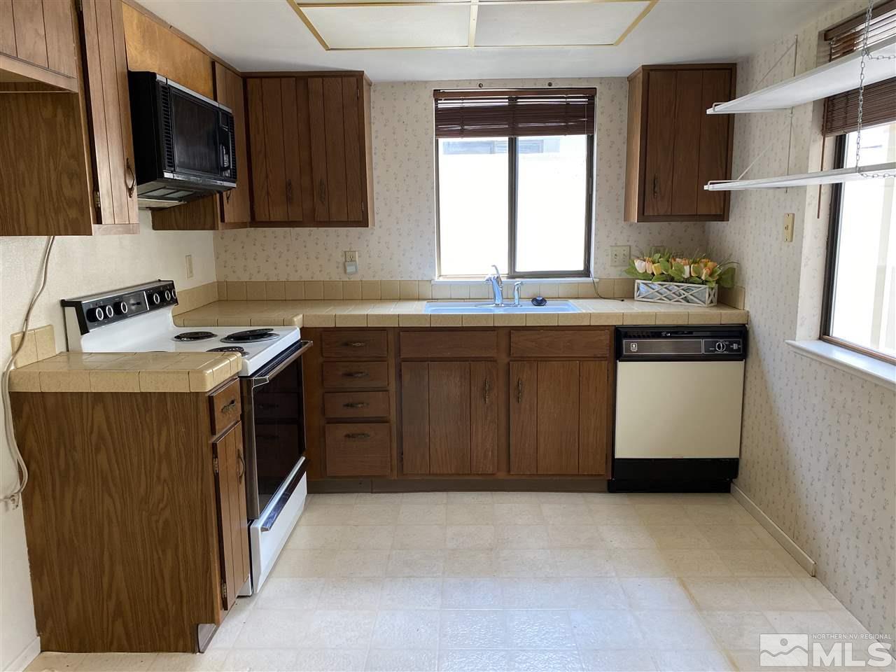 1207 Searchlite Court Reno, NV 89503 - Photo 7 of 17 a kitchen with stainless steel appliances granite countertop a stove a sink and a microwave