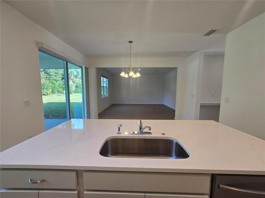 1147 Happy Frst Loop DeLand, FL 32720 - Photo 4 of 10 a view of a kitchen with a sink and chandelier