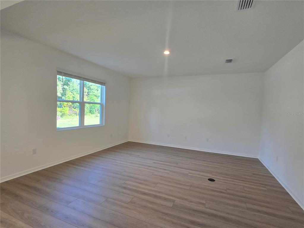 1147 Happy Frst Loop DeLand, FL 32720 - Photo 5 of 10 wooden floor in an empty room with a window