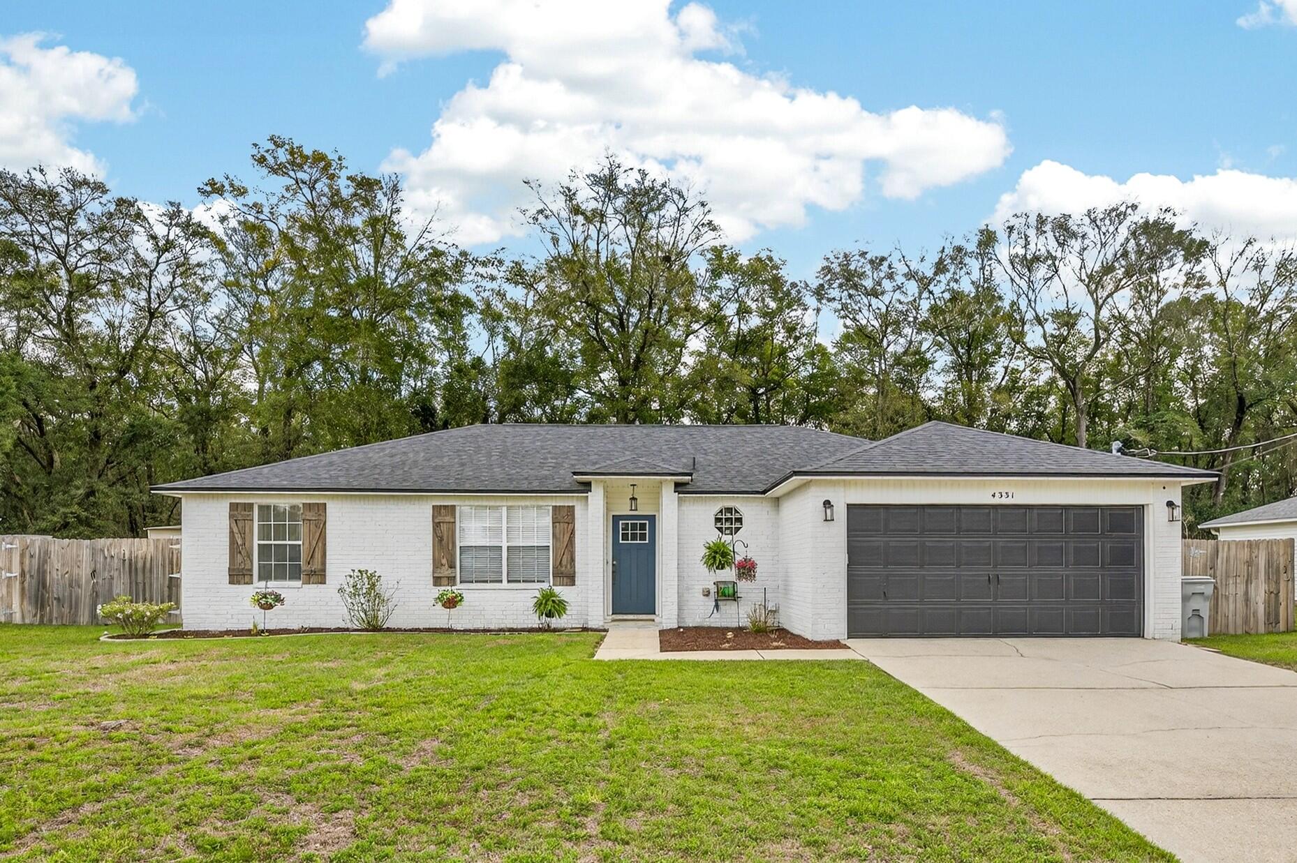 4331 Crosswind Drive Milton, FL 32583 - Photo 1 of 50 a front view of a house with a yard and garage