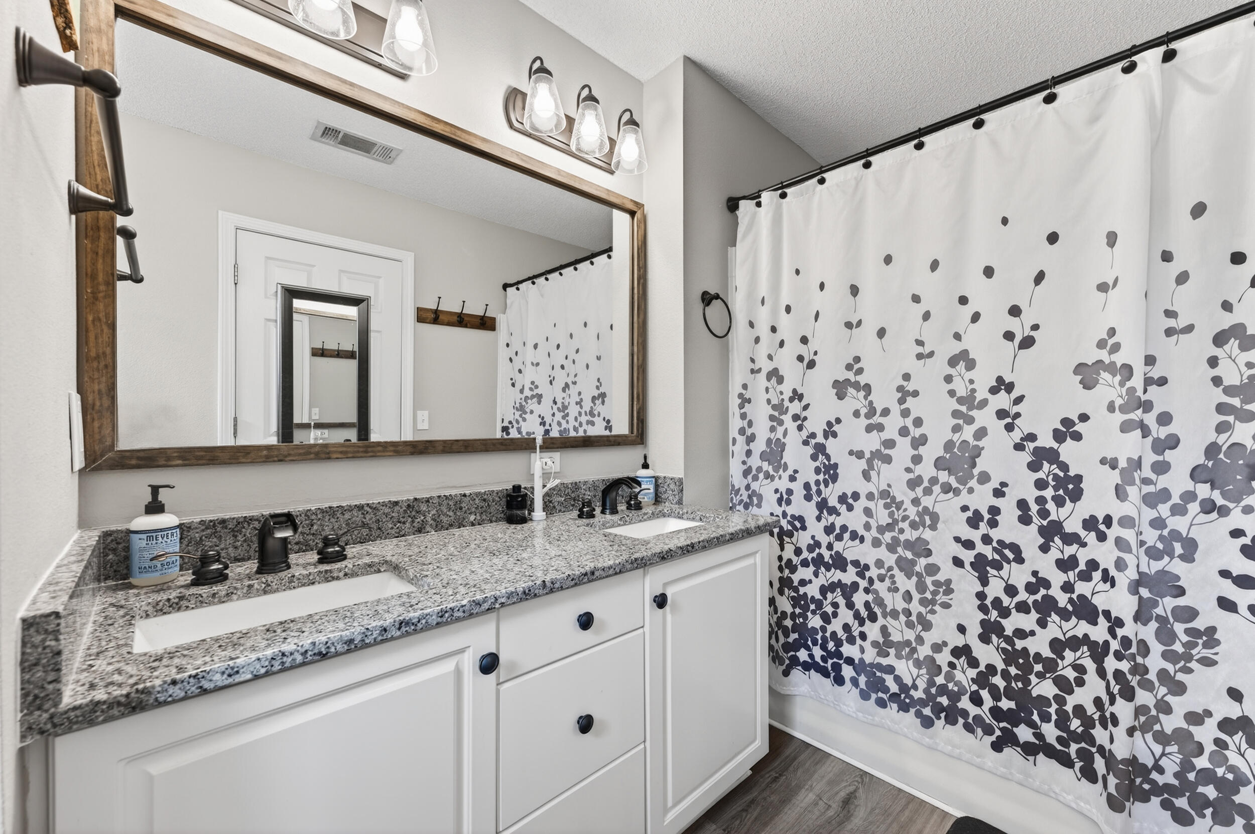 4331 Crosswind Drive Milton, FL 32583 - Photo 25 of 50 a bathroom with a granite countertop sink a mirror a and a shower curtain