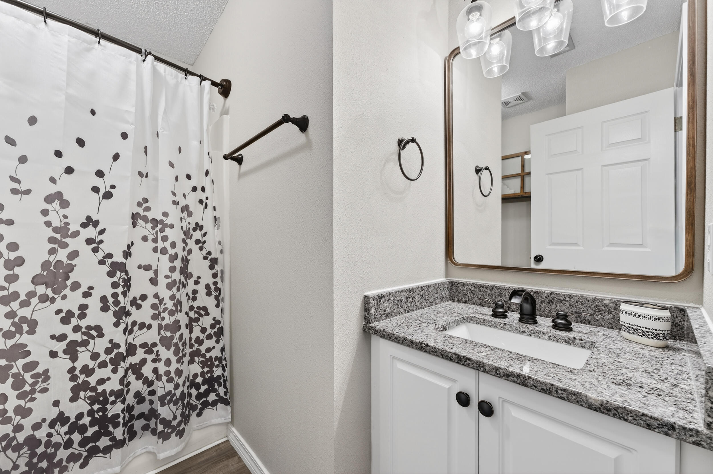 4331 Crosswind Drive Milton, FL 32583 - Photo 33 of 50 a bathroom with a granite countertop sink a mirror a vanity and a shower