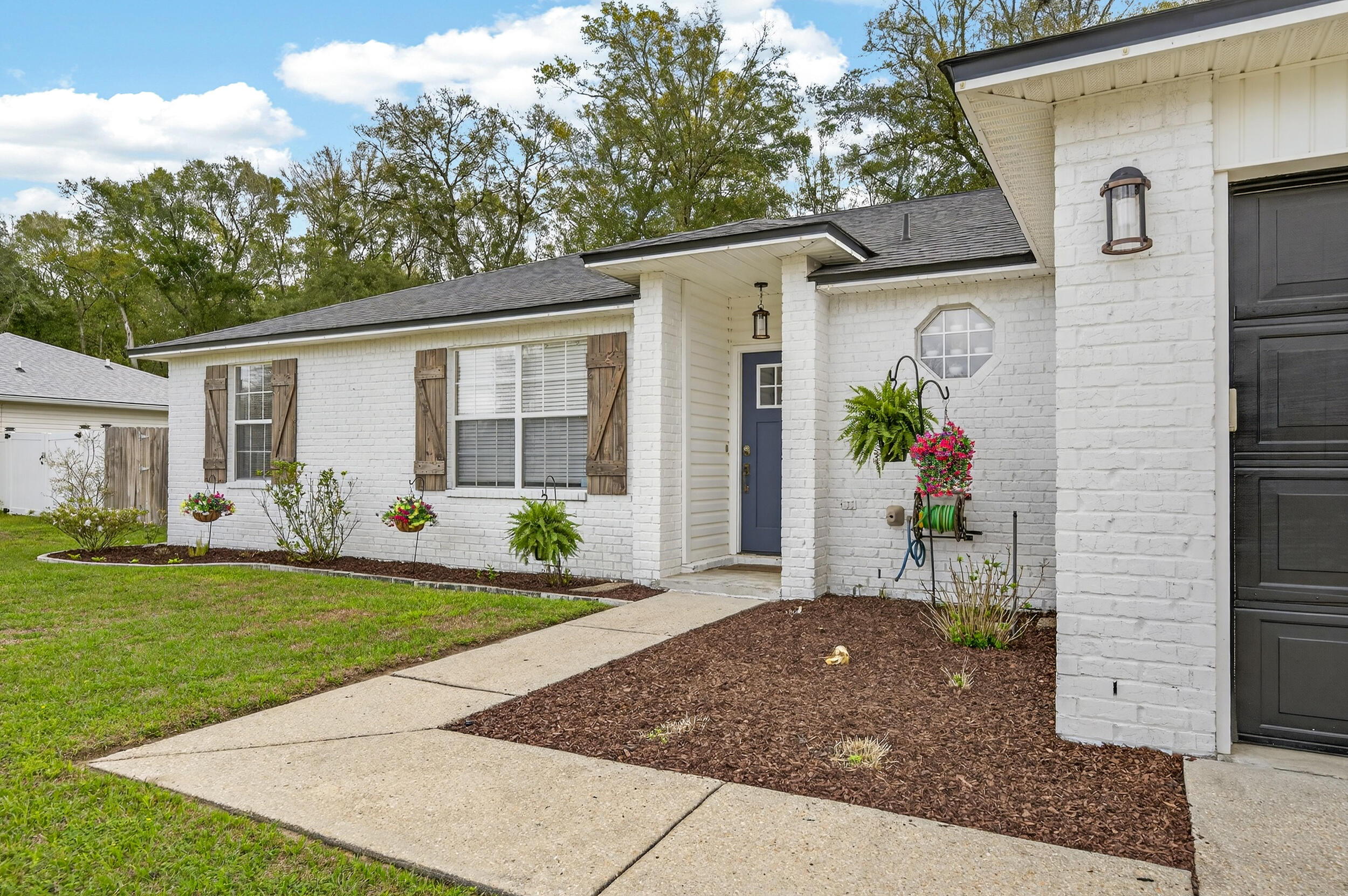 4331 Crosswind Drive Milton, FL 32583 - Photo 49 of 50 a front view of a house with a garden and yard