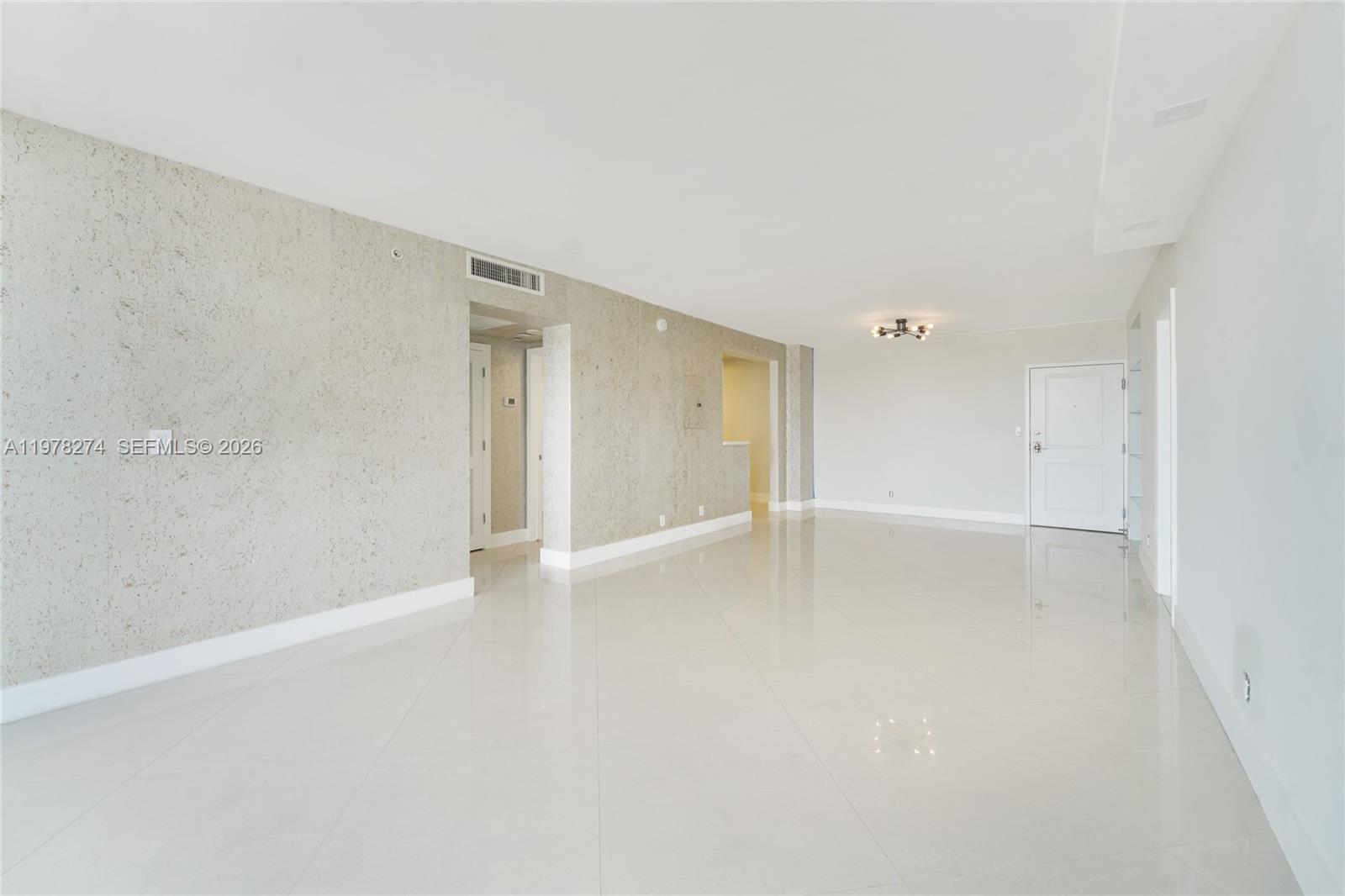 401 69th Street, Unit 913 Miami Beach, FL 33141 - Photo 3 of 26 a view of an empty room with wooden floor and a window