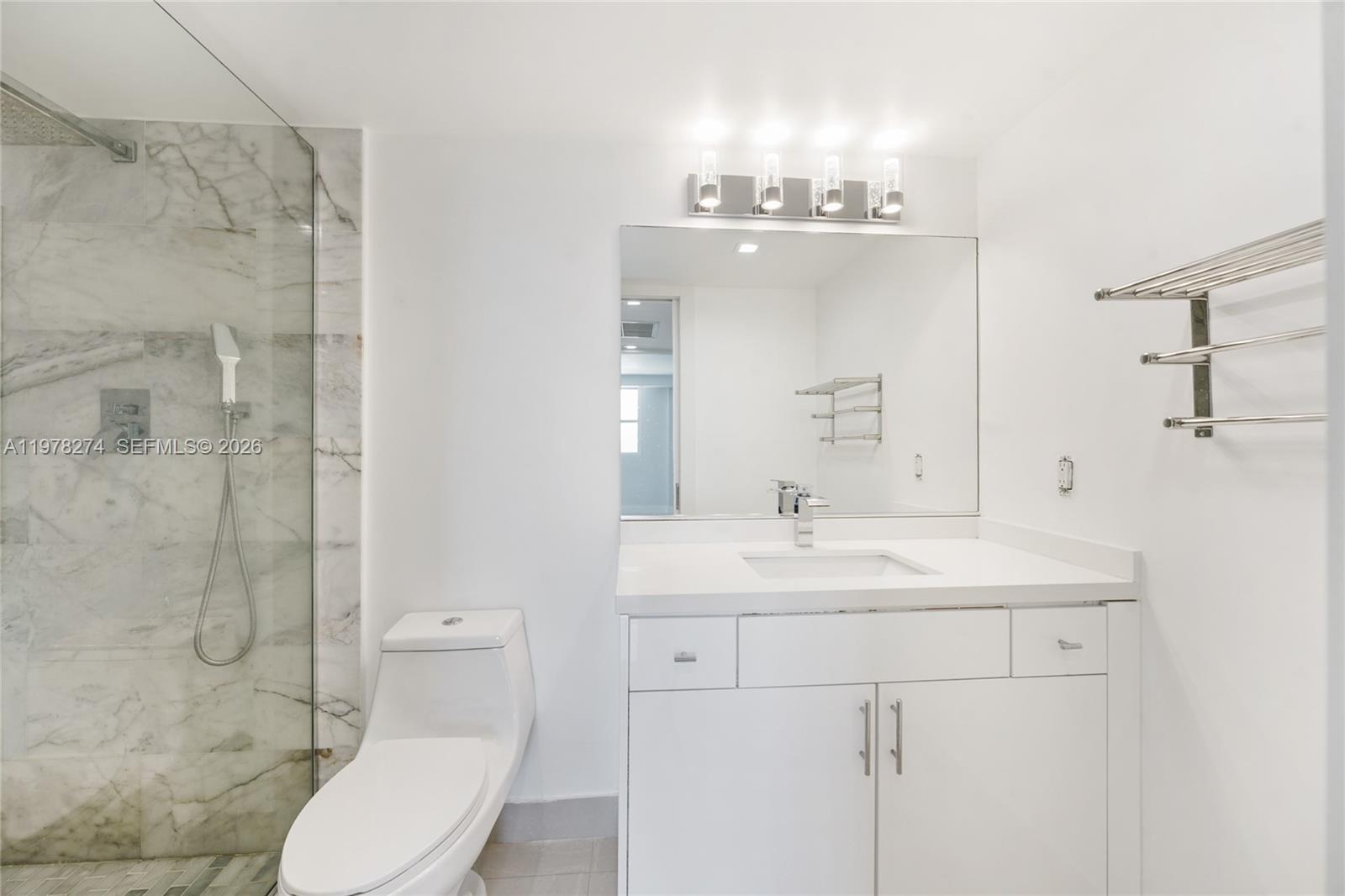 401 69th Street, Unit 913 Miami Beach, FL 33141 - Photo 7 of 26 a bathroom with a sink toilet mirror and shower