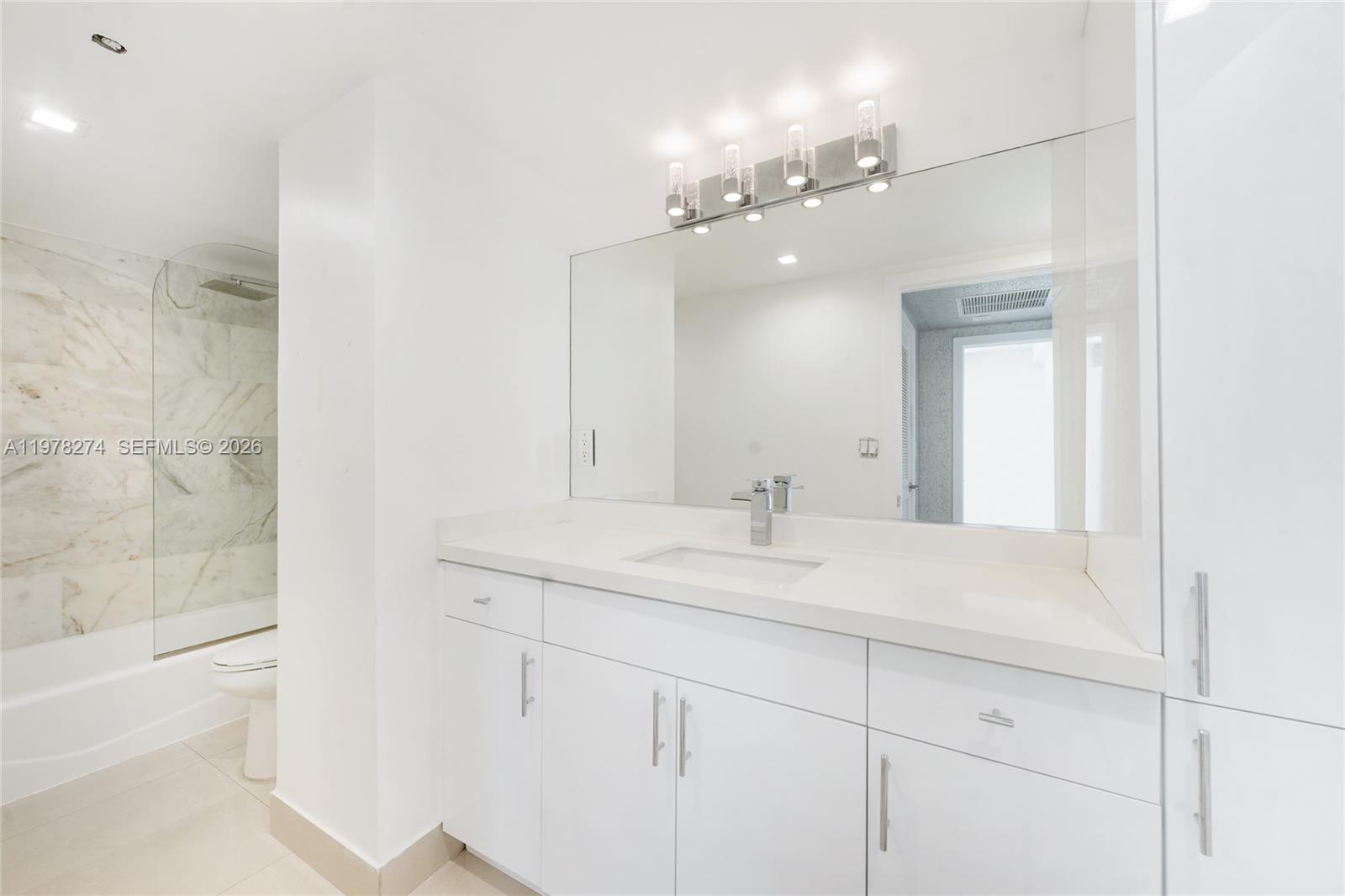 401 69th Street, Unit 913 Miami Beach, FL 33141 - Photo 8 of 26 a bathroom with a sink a vanity and a mirror
