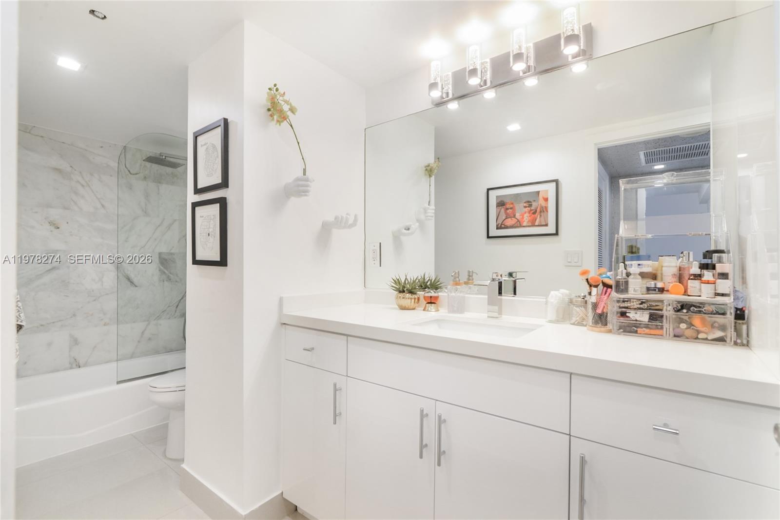 401 69th Street, Unit 913 Miami Beach, FL 33141 - Photo 10 of 26 a bathroom with a sink a toilet and shower