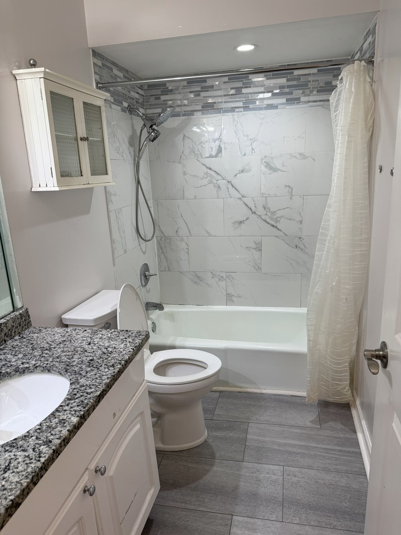6027 103rd Street, Unit 1A Chicago Ridge, IL 60415 - Photo 19 of 22 a bathroom with a granite countertop sink toilet and shower