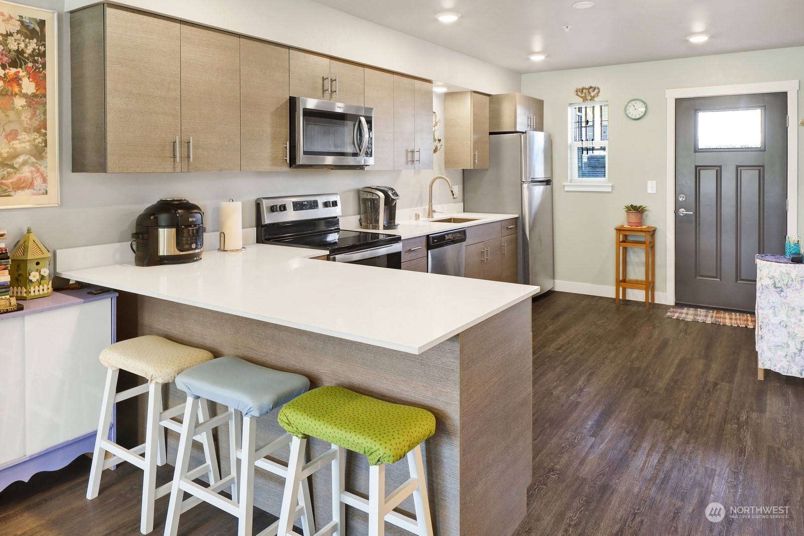 1882 Front Street, Unit 111 Lynden, WA 98264 - Photo 11 of 29 a kitchen with stainless steel appliances a stove a sink dishwasher and a refrigerator with wooden floor