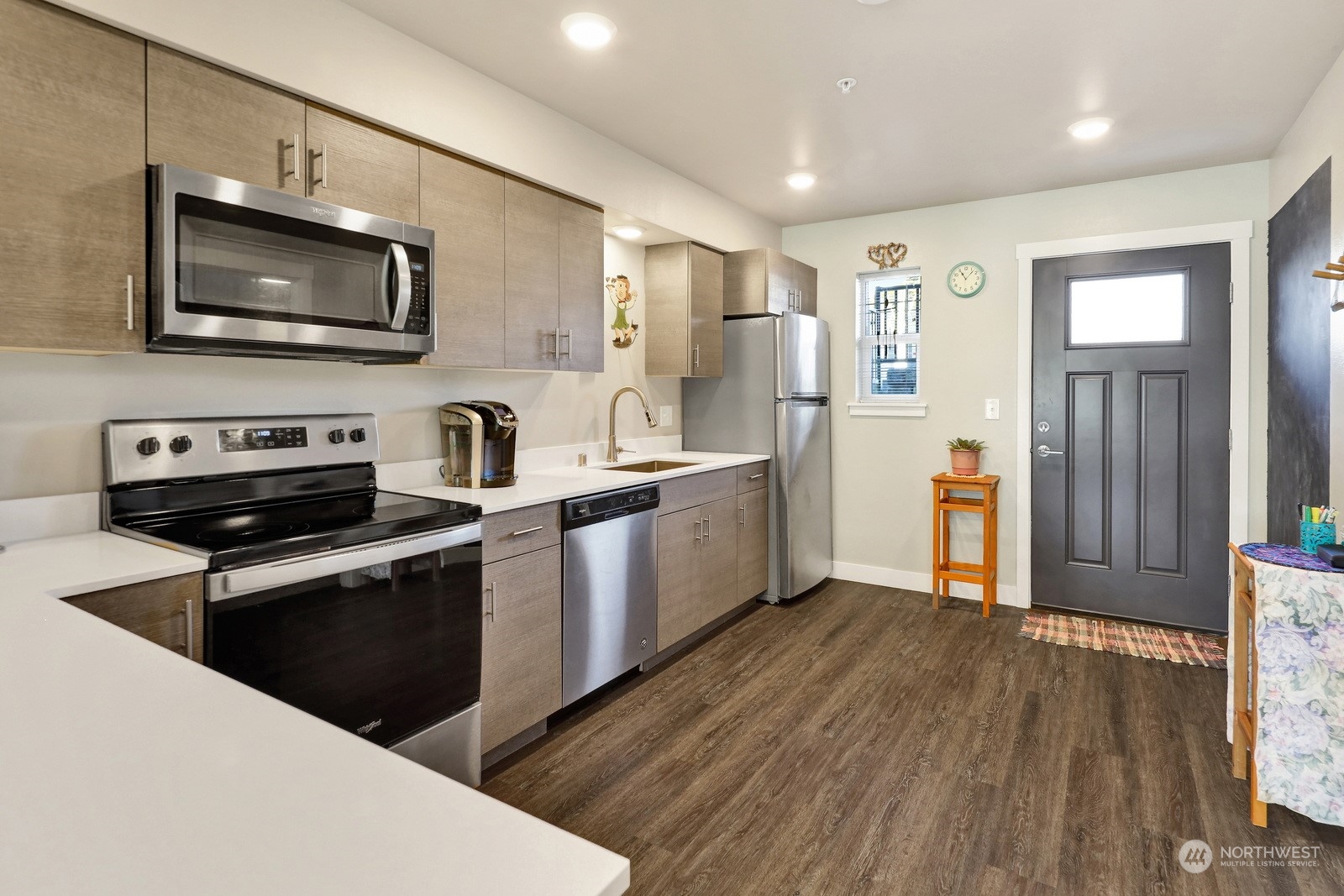 1882 Front Street, Unit 111 Lynden, WA 98264 - Photo 5 of 29 a kitchen with stainless steel appliances granite countertop a refrigerator a stove top oven a sink dishwasher and wooden floor