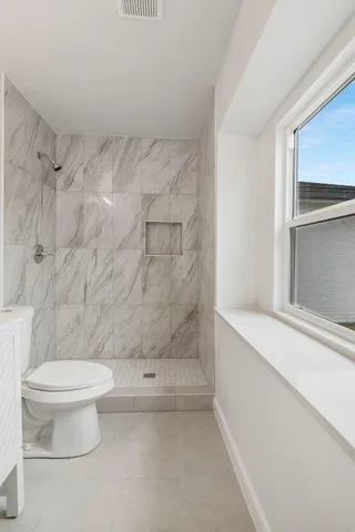 a bathroom with a toilet and a shower