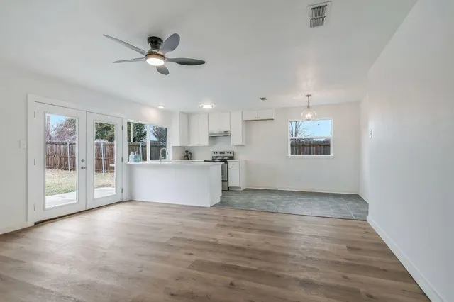 a view of a kitchen with wooden floor and a window