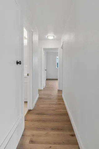 a view of a hallway with wooden floor