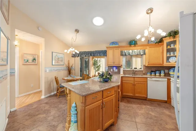 a kitchen with a refrigerator a stove and a dining table with wooden cabinet