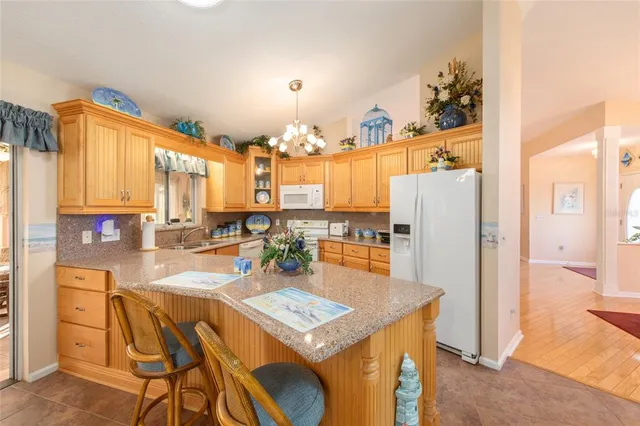 a view of a kitchen with kitchen island granite countertop a large counter top space and stainless steel appliances