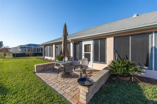 a view of a house with backyard sitting area and garden