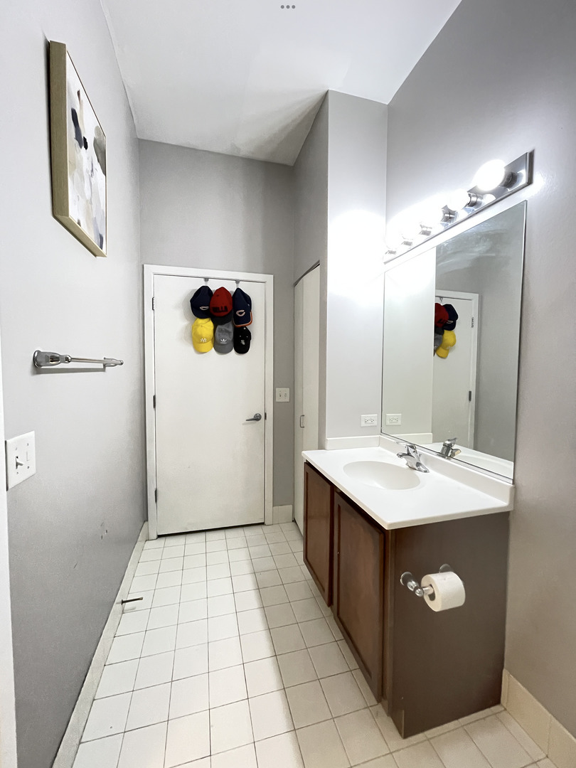 2323 West Pershing Road, Unit 421 Chicago, IL 60609 - Photo 10 of 15 a bathroom with a sink a toilet and mirror