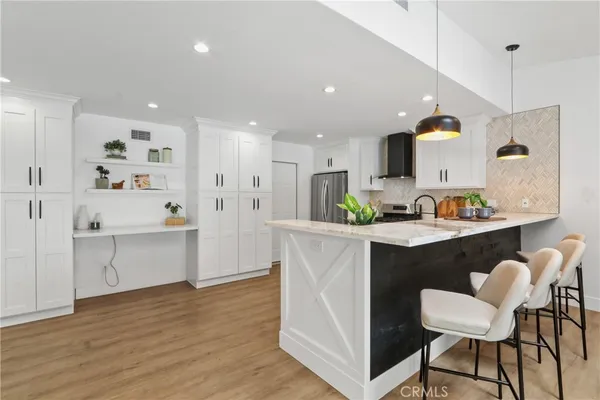 a kitchen with white cabinets and chairs