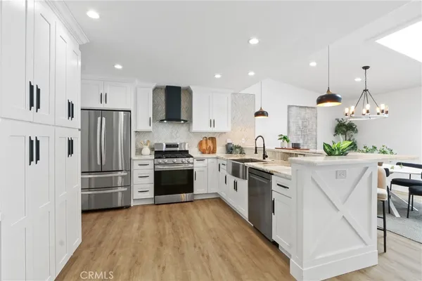 a kitchen with kitchen island white cabinets and stainless steel appliances