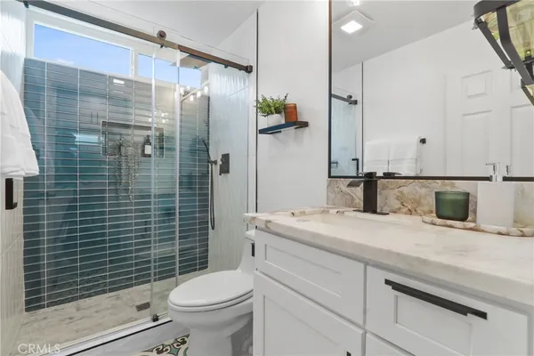 a bathroom with a sink a toilet and shower
