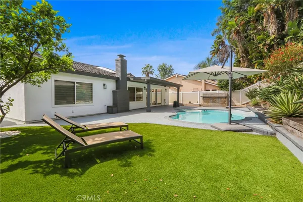 a swimming pool with outdoor seating and yard