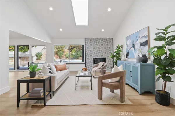 a living room with furniture a potted plant and a fireplace