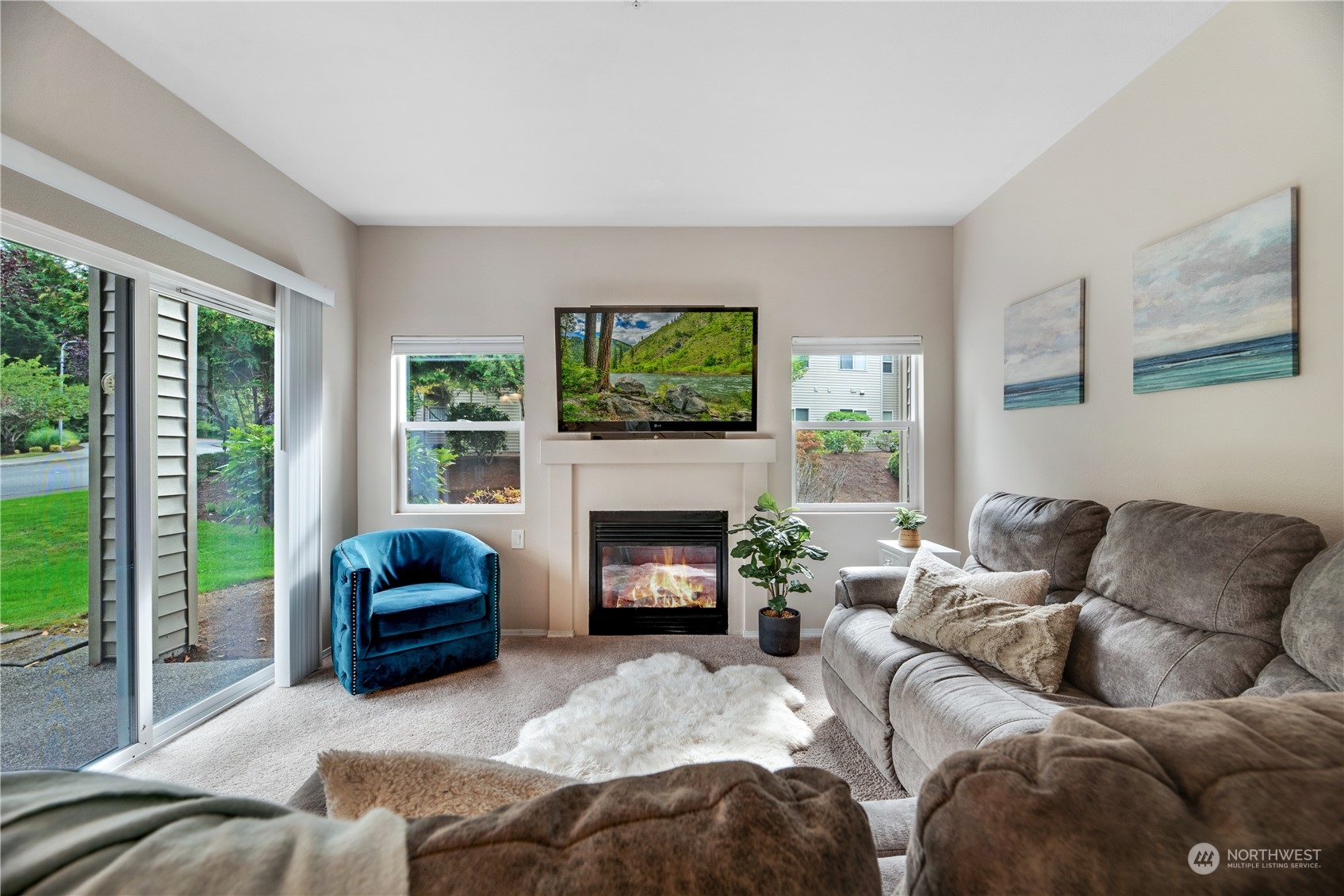 17604 134th Lane Southeast, Unit 17604 Renton, WA 98058 - Photo 3 of 25 a living room with furniture flat screen tv and a fireplace