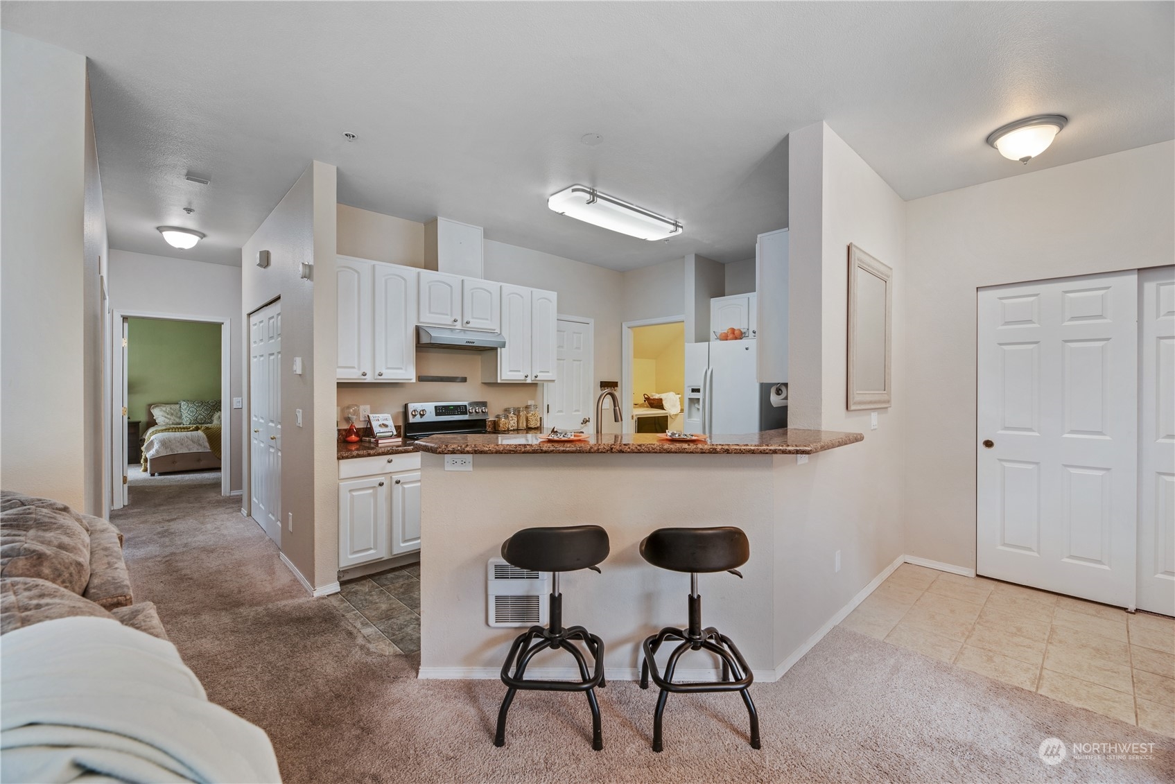 17604 134th Lane Southeast, Unit 17604 Renton, WA 98058 - Photo 5 of 25 a kitchen with stainless steel appliances granite countertop a refrigerator and a stove top oven