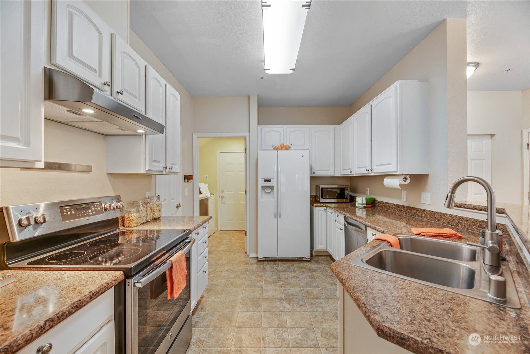 17604 134th Lane Southeast, Unit 17604 Renton, WA 98058 - Photo 6 of 25 a kitchen with stainless steel appliances granite countertop a sink stove and refrigerator