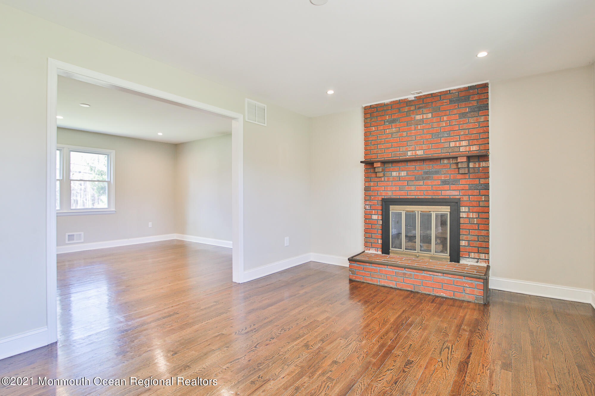 525 Frank Applegate Road Jackson, NJ 08527 - Photo 10 of 56 an empty room with wooden floor and fireplace