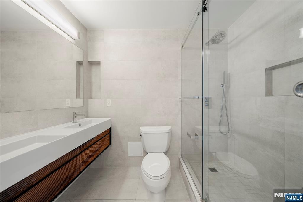 200 Old Palisade Road, Unit 25D Fort Lee, NJ 07024 - Photo 15 of 30 a bathroom with a granite countertop toilet a sink and a bathtub