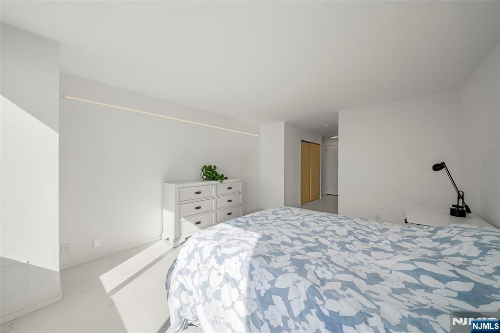 200 Old Palisade Road, Unit 25D Fort Lee, NJ 07024 - Photo 19 of 30 a bedroom with a bed and a potted plant