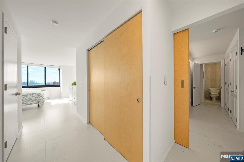200 Old Palisade Road, Unit 25D Fort Lee, NJ 07024 - Photo 21 of 30 a view of a hallway with wooden floor and a living room