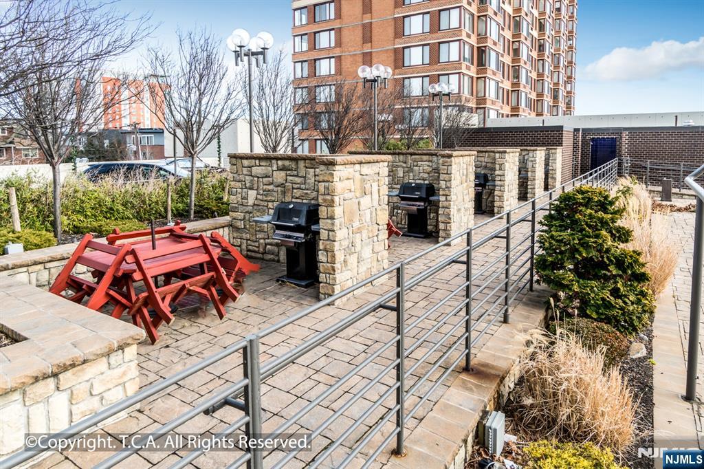 200 Old Palisade Road, Unit 25D Fort Lee, NJ 07024 - Photo 29 of 30 a view of a patio with table and chairs and potted plants
