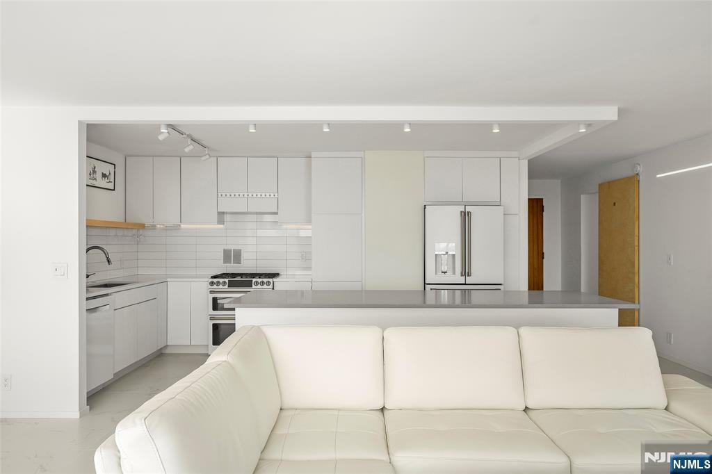 200 Old Palisade Road, Unit 25D Fort Lee, NJ 07024 - Photo 7 of 30 a kitchen with stainless steel appliances granite countertop a sink and cabinets