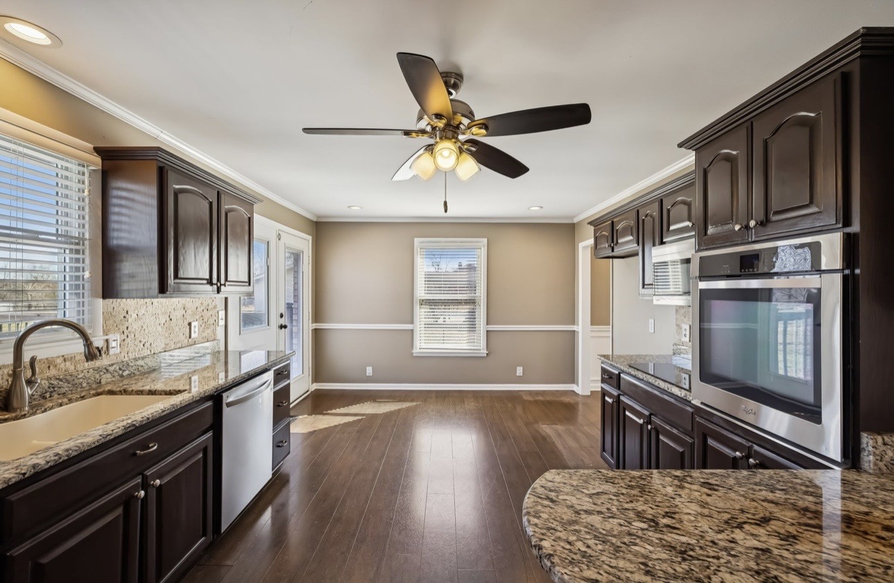 6580 Burkitt Road Antioch, TN 37013 - Photo 11 of 62 a kitchen with stainless steel appliances granite countertop a stove a sink and a microwave