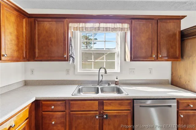 a kitchen with stainless steel appliances granite countertop a sink a microwave cabinets and a window