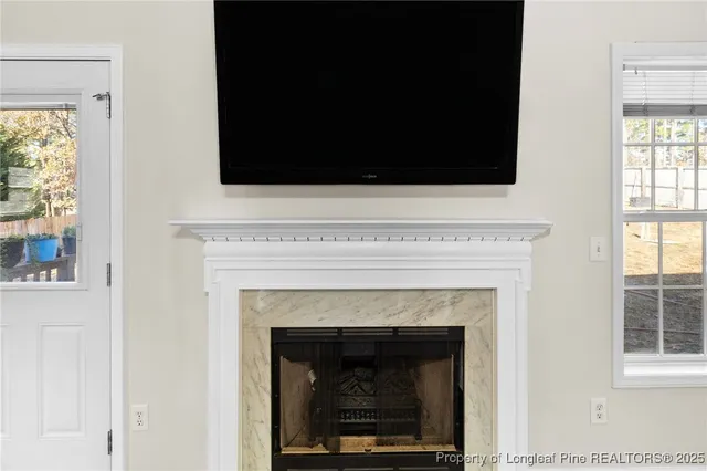 a living room with a fireplace and a flat screen tv