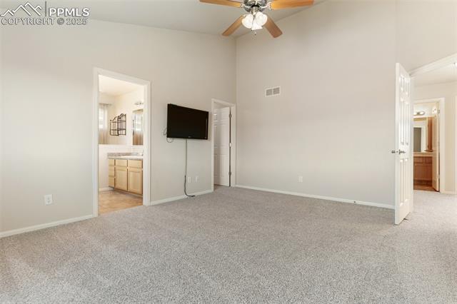4540 Sierra Rica Road Colorado Springs, CO 80911 - Photo 30 of 42 Unfurnished bedroom featuring ensuite bath, light colored carpet, high vaulted ceiling, and ceiling fan