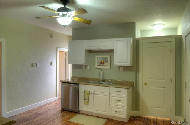 a bathroom with a granite countertop sink a light fixture and a mirror