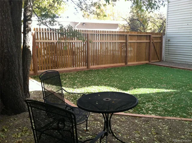 a view of a chairs and table in backyard