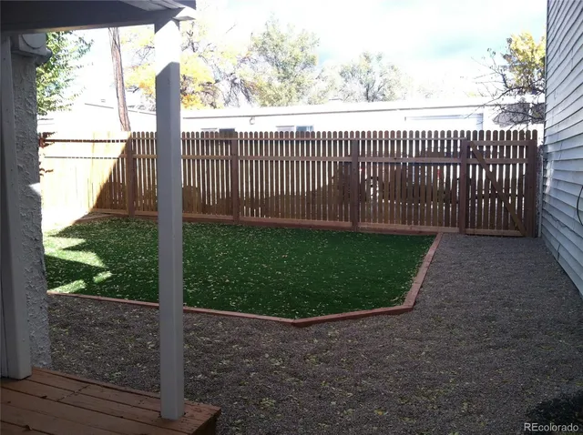 a view of a yard with wooden fence