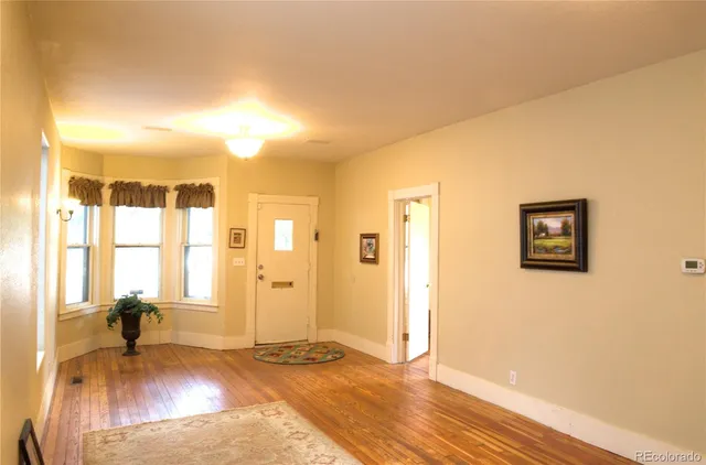 a view of a livingroom with wooden floor and a flat screen tv