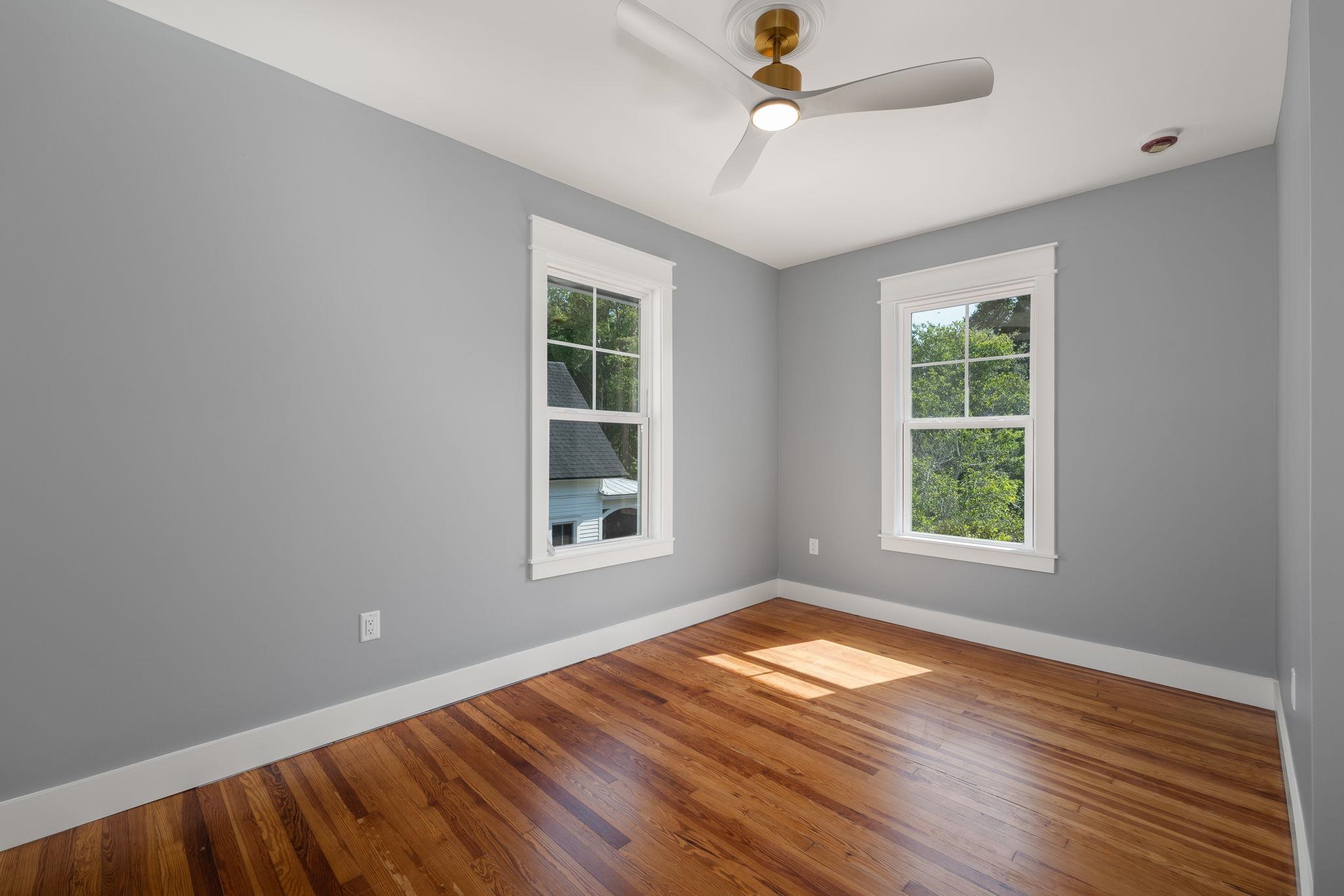 142 Washington Street St. Augustine, FL 32084 - Photo 47 of 53 an empty room with wooden floor ceiling fan and windows