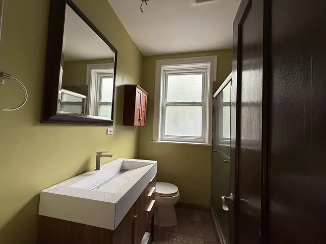 a bathroom with a toilet a sink and mirror