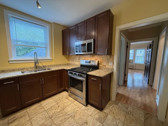 a kitchen with stainless steel appliances granite countertop wooden cabinets a sink and a stove