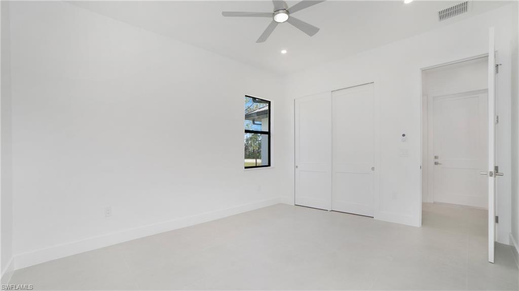 2343 Oil Well Road Naples, FL 34120 - Photo 12 of 46 Spacious room featuring light-toned flooring, a window with black trim, a ceiling fan, recessed lighting, and a double sliding closet door