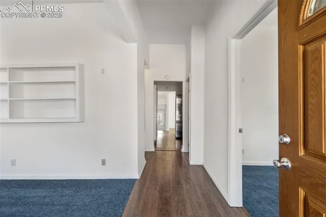 a view of a hallway with wooden floor and staircase