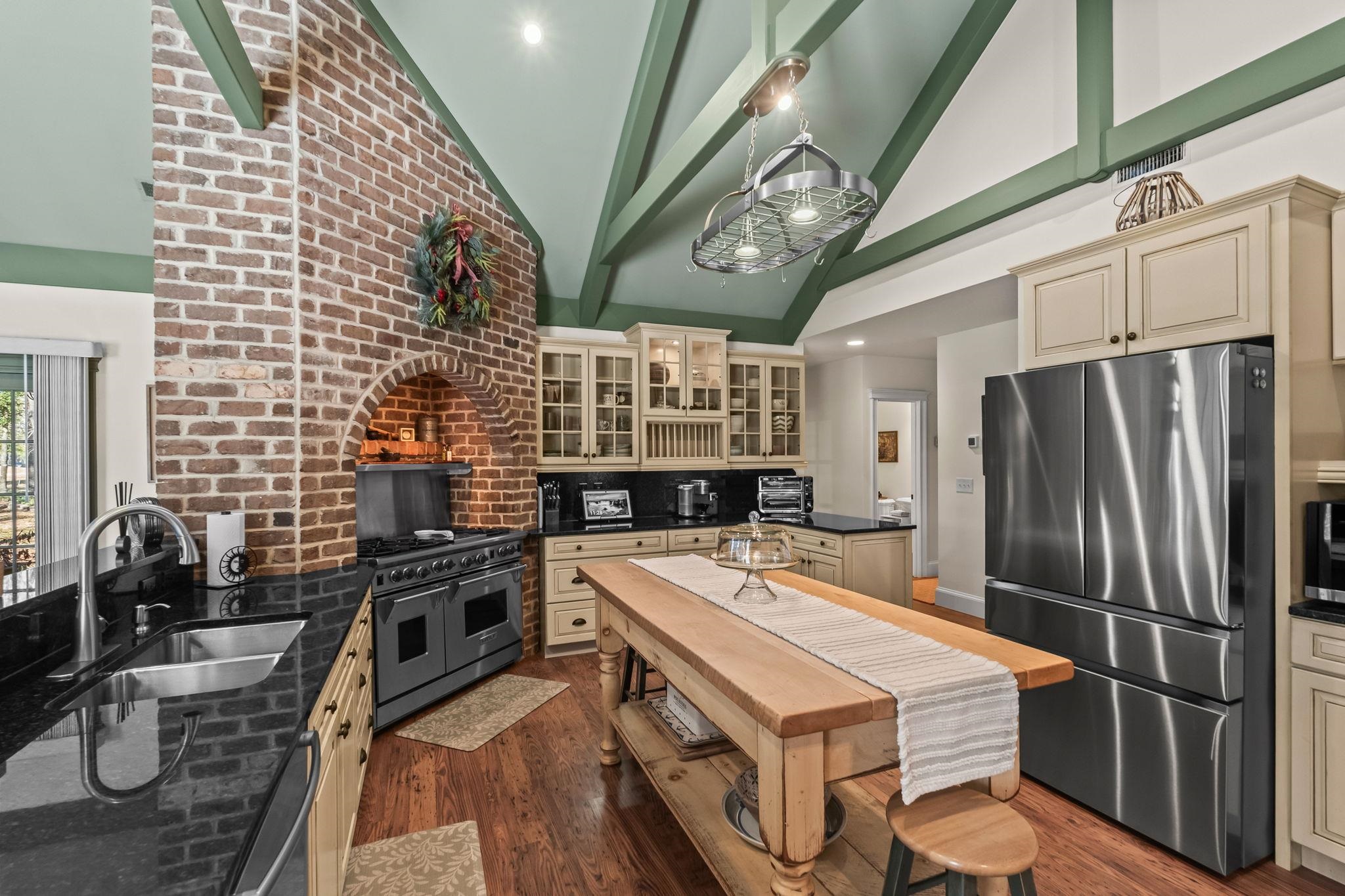 400 Foxtail Drive Longs, SC 29568 - Photo 18 of 40 Kitchen with stainless steel appliances, cream cabinetry, glass insert cabinets, beamed ceiling, and dark wood finished floors